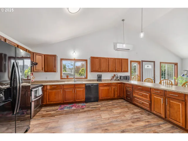 a kitchen with stainless steel appliances granite countertop a refrigerator a sink dishwasher a stove with wooden cabinets