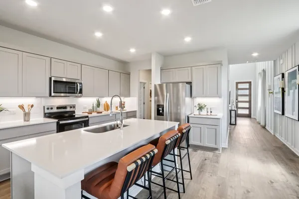 a kitchen with white cabinets and stainless steel appliances