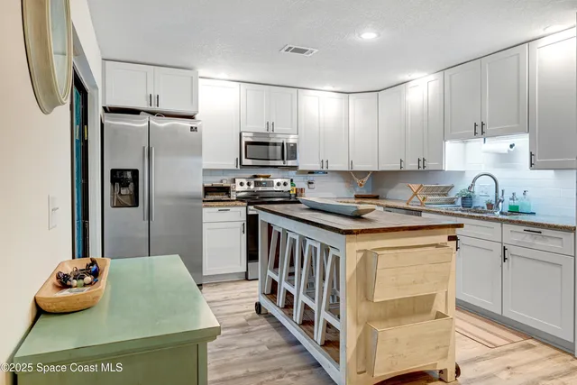a kitchen with stainless steel appliances granite countertop a stove a sink dishwasher a refrigerator and a oven