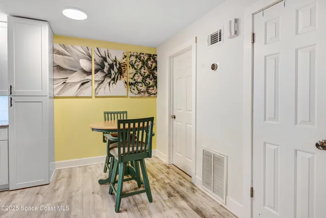 a view of a hallway with wooden floor and dining room