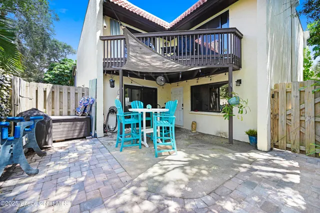 a view of a chair with floor to ceiling window and wooden fence