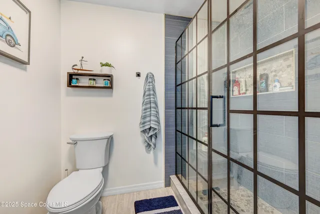 a white toilet sitting next to a shower