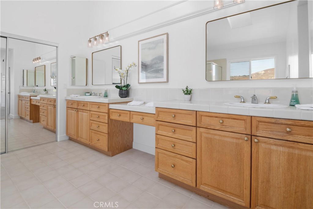 3966 Leighton Point Road Calabasas, CA 91301 - Photo 14 of 37 a spacious bathroom with a granite countertop sink and mirror