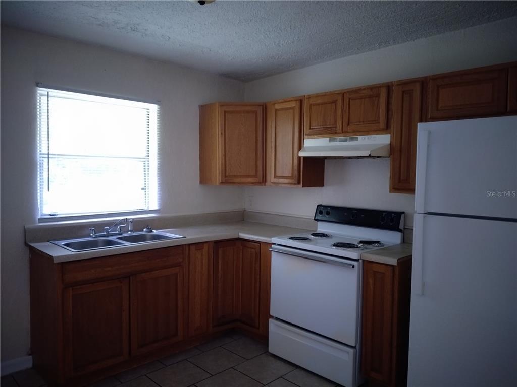 2008 Northwest 14th Street Ocala, FL 34475 - Photo 9 of 18 a kitchen with a stove a sink and a refrigerator