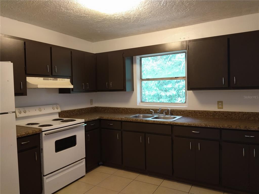 2008 Northwest 14th Street Ocala, FL 34475 - Photo 10 of 18 a kitchen with a sink stove and microwave