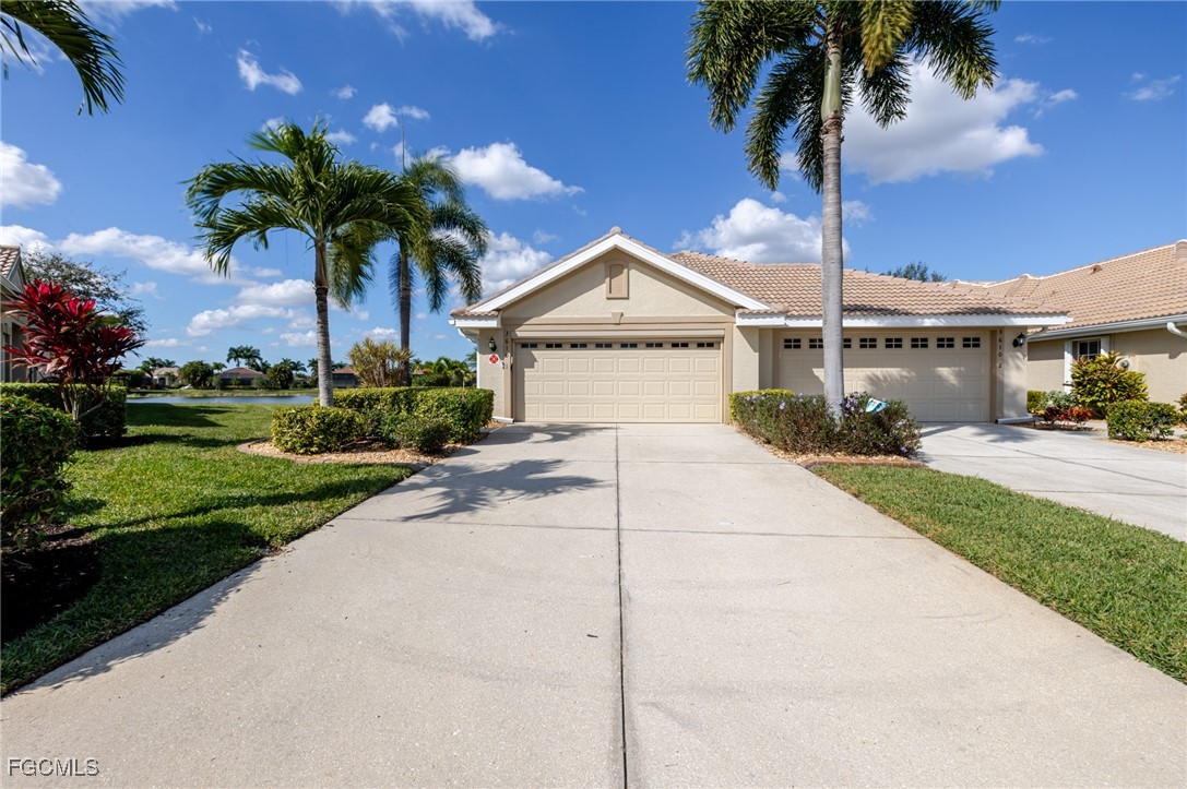 a front view of a house with a garden and palm trees