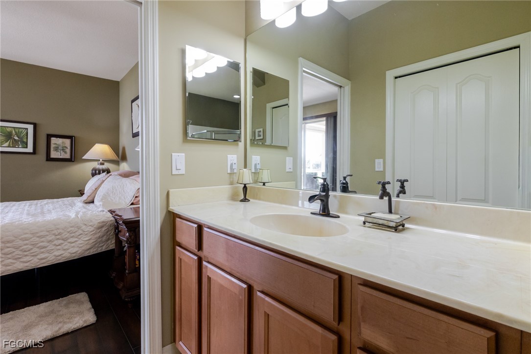 3610 Rue Alec Loop, Unit 1 North Fort Myers, FL 33917 - Photo 25 of 39 a en suite bathroom with a granite countertop sink and a mirror