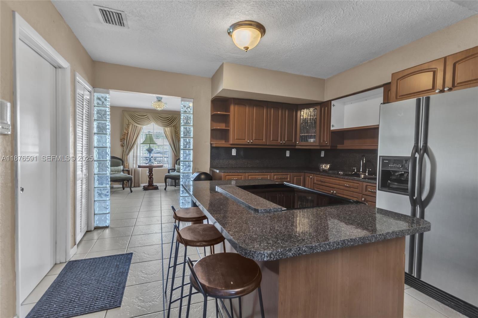 22270 Southwest 109th Avenue Miami, FL 33176 - Photo 13 of 48 a kitchen with granite countertop a sink refrigerator and cabinets