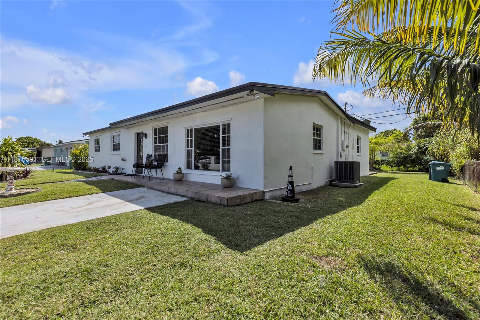 22270 Southwest 109th Avenue Miami, FL 33176 - Photo 38 of 48 a view of a white house with a yard plants and palm trees