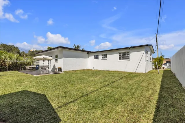 a view of a patio with a table and chairs under an umbrella