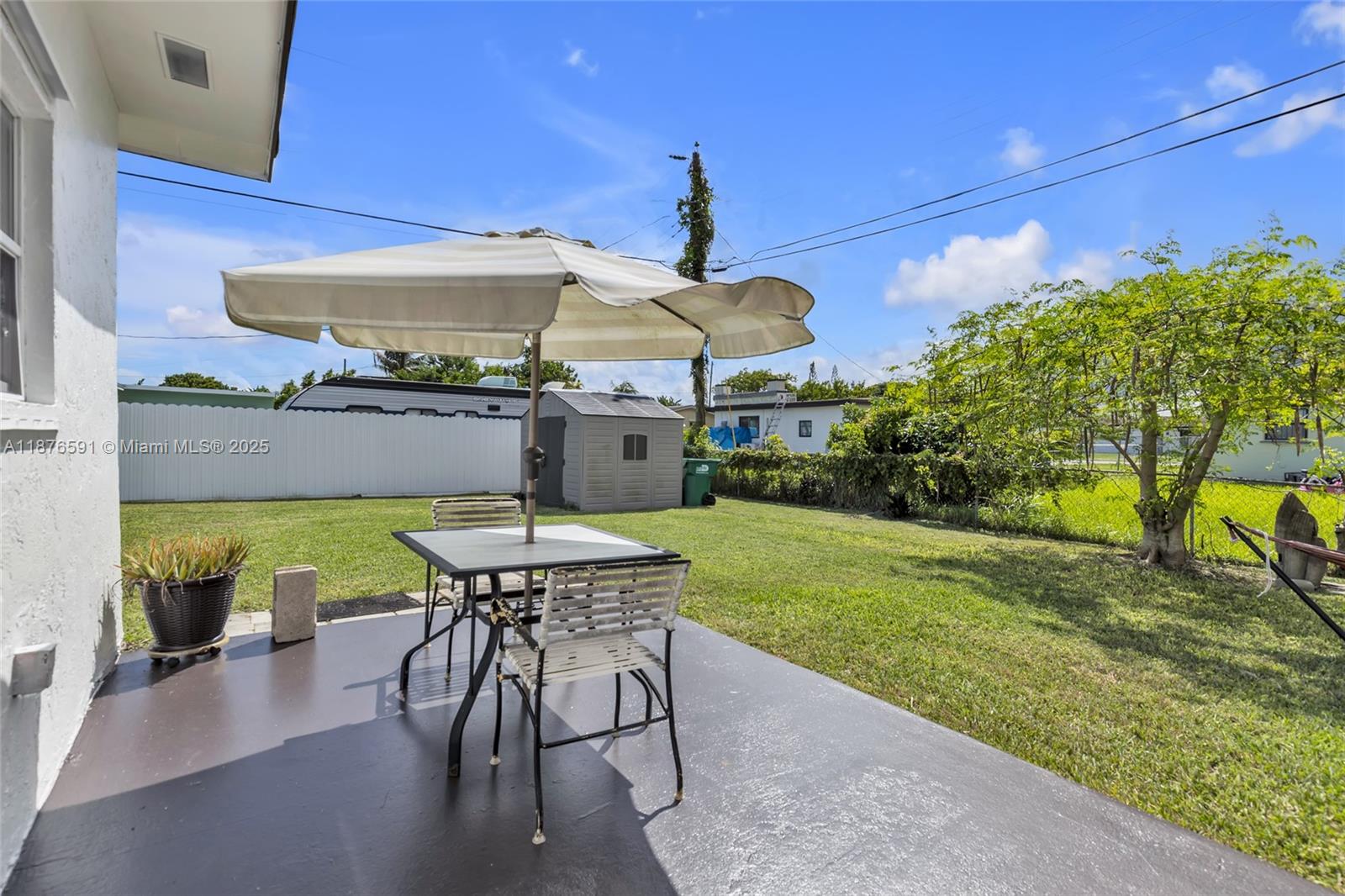 22270 Southwest 109th Avenue Miami, FL 33176 - Photo 47 of 48 a view of a patio with a table and chairs under an umbrella