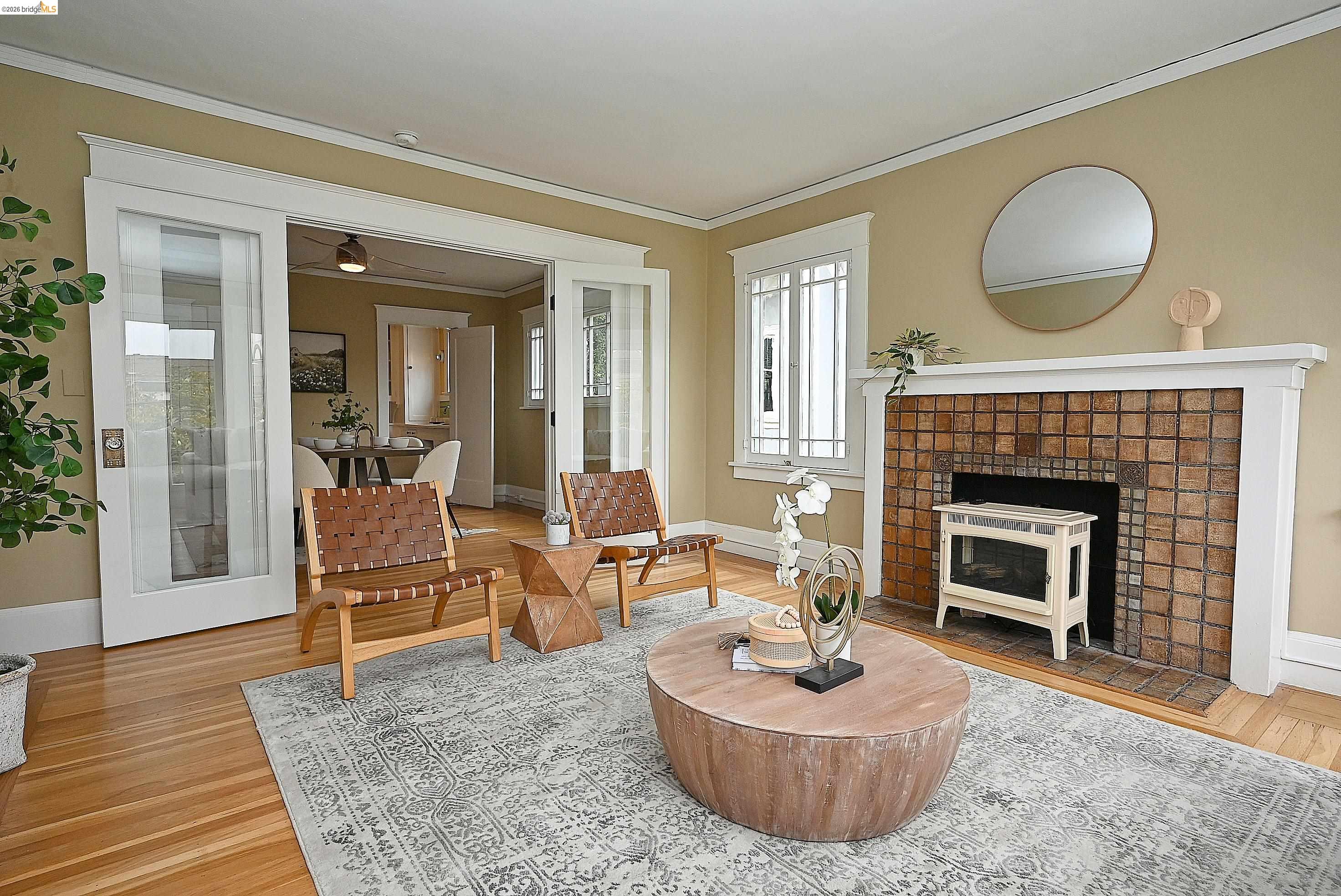 1301 Bonita Avenue, Unit 3 Berkeley, CA 94709 - Photo 10 of 48 Living area featuring hardwood flooring, a tiled fireplace with mantel, and white trim