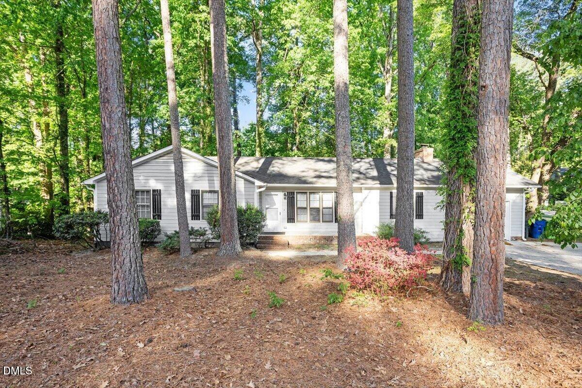 8233 Clear Brook Drive Raleigh, NC 27615 - Photo 1 of 28 a front view of a house with a yard table and chairs