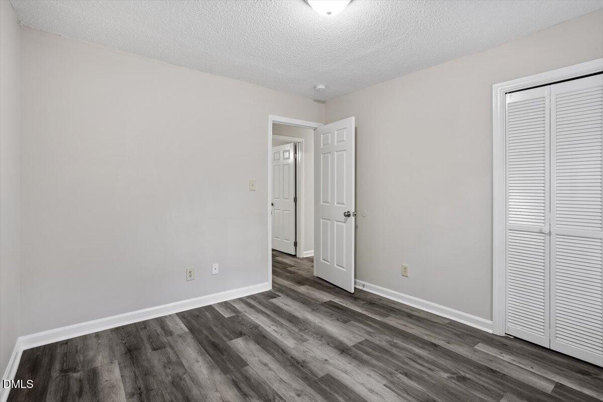 8233 Clear Brook Drive Raleigh, NC 27615 - Photo 21 of 28 an empty room with wooden floor and closet