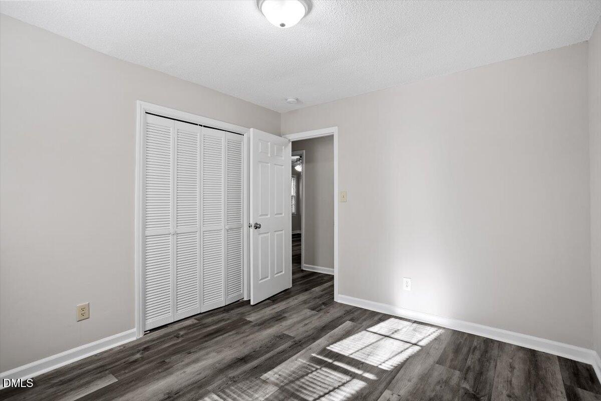 8233 Clear Brook Drive Raleigh, NC 27615 - Photo 24 of 28 a view of an empty room with wooden floor