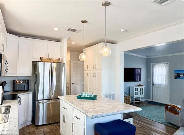 a kitchen with sink refrigerator cabinets and dining table