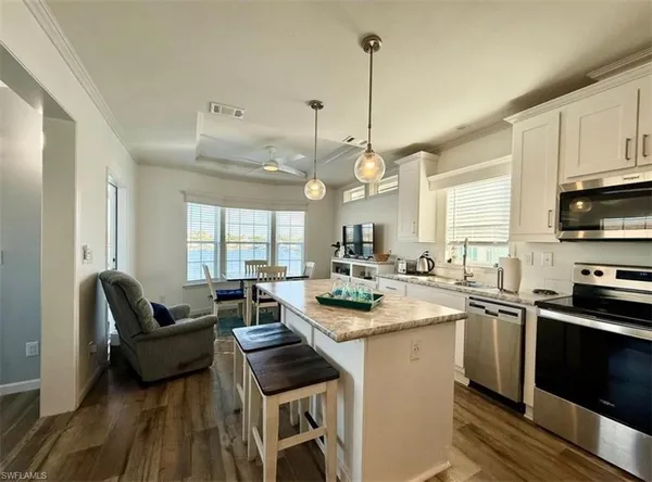 a kitchen with a stove a counter space a sink dining table and chairs