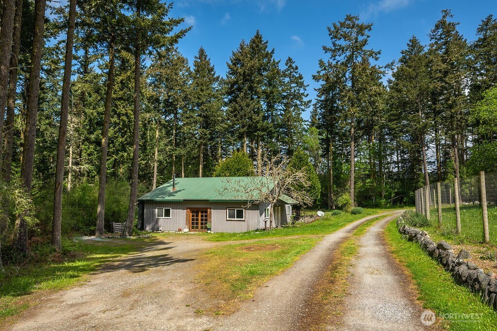 343 Burt Road Lopez Island, WA 98261 - Photo 32 of 39 a view of a big house with a big yard and large trees