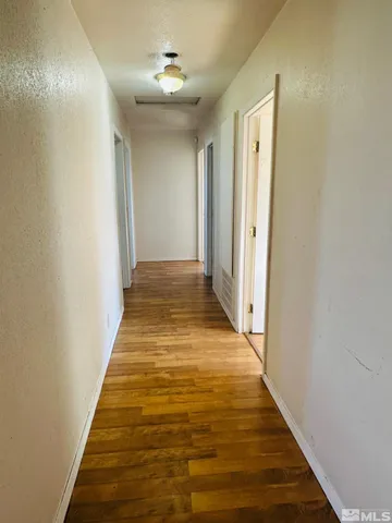 a view of a hallway with wooden floor