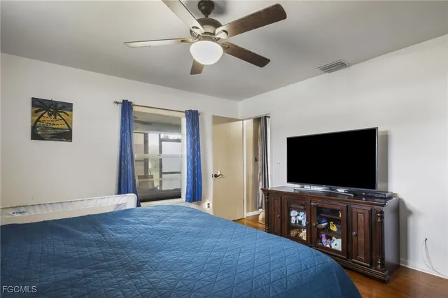 a living room with flat screen tv and a ceiling fan