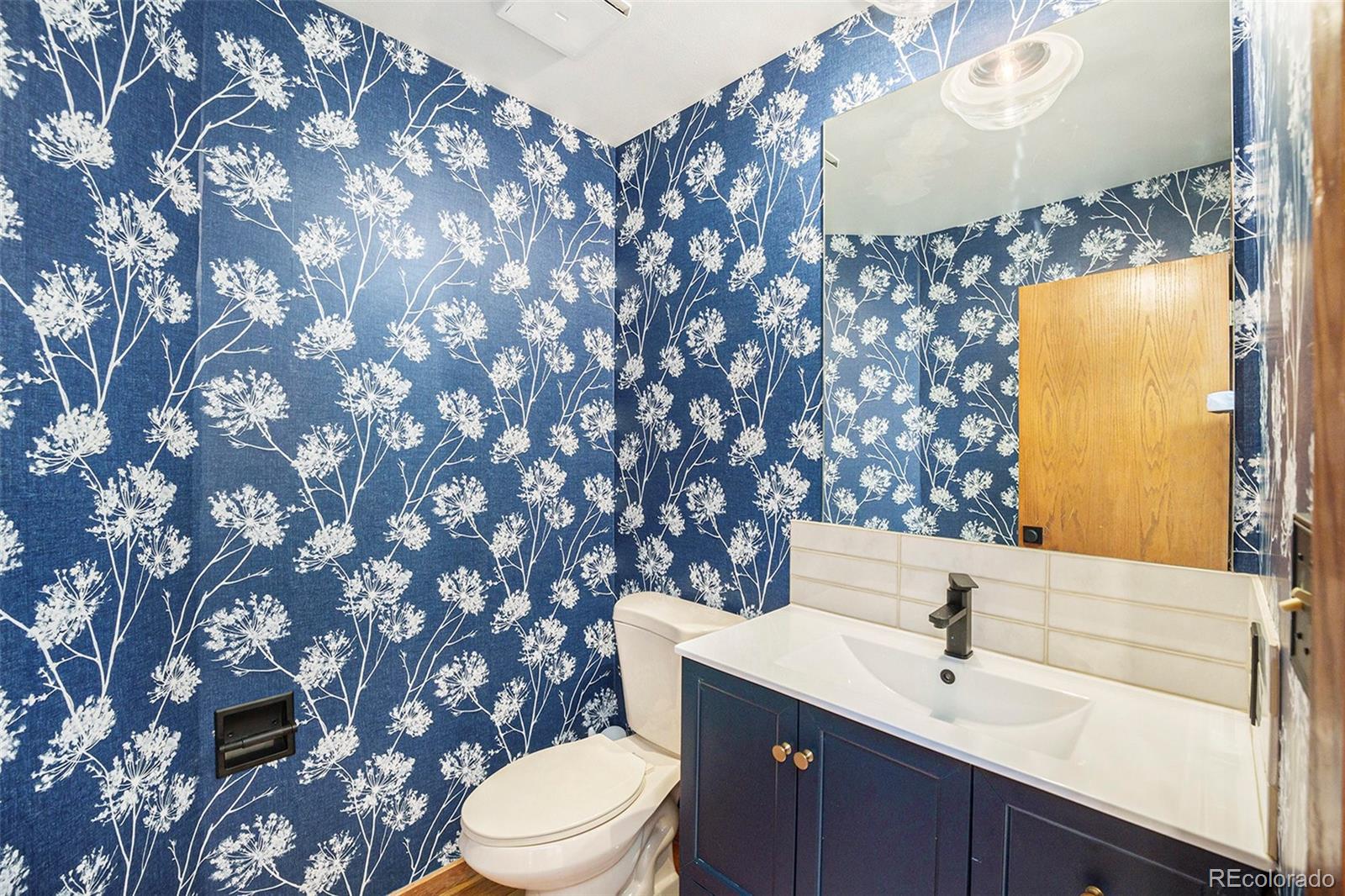 23526 Currant Drive Golden, CO 80401 - Photo 14 of 30 a bathroom with a sink mirror vanity and toilet