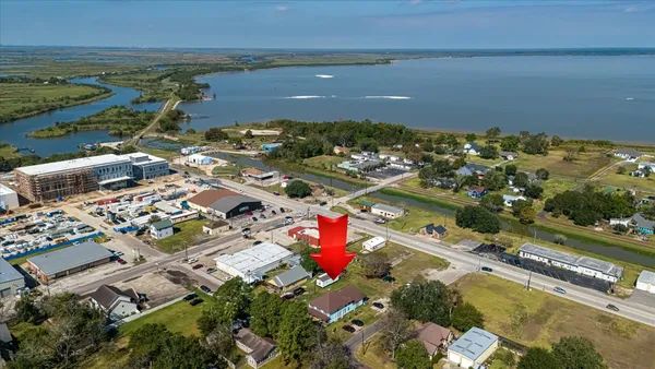 an aerial view of ocean and residential houses with outdoor space