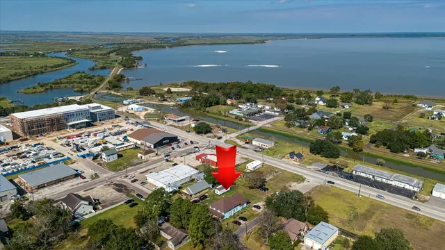 an aerial view of ocean and residential houses with outdoor space