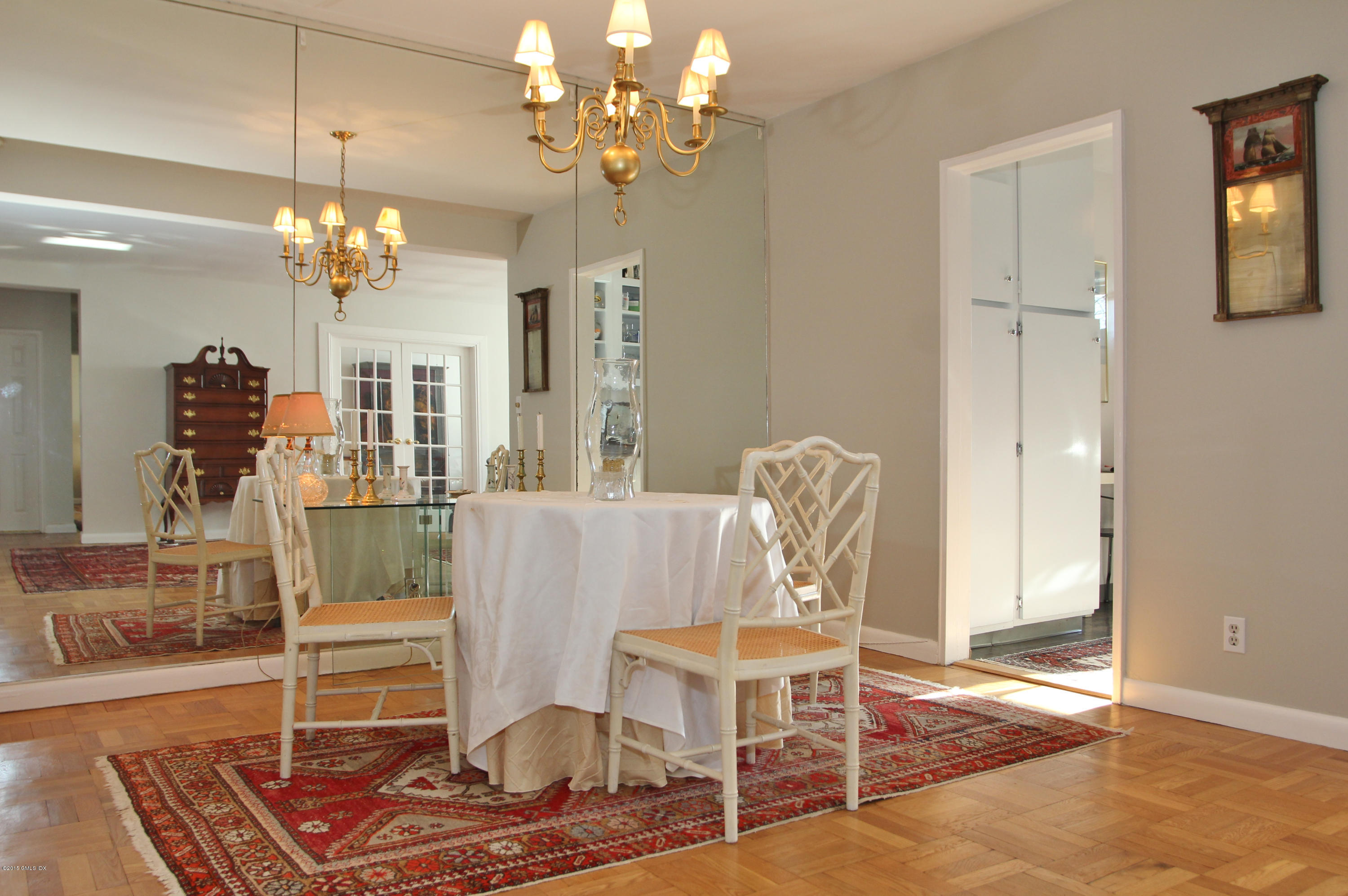 5 Putnam Hill, Unit 1F Greenwich, CT 06830 - Photo 9 of 18 a living room with dining table and a chandelier