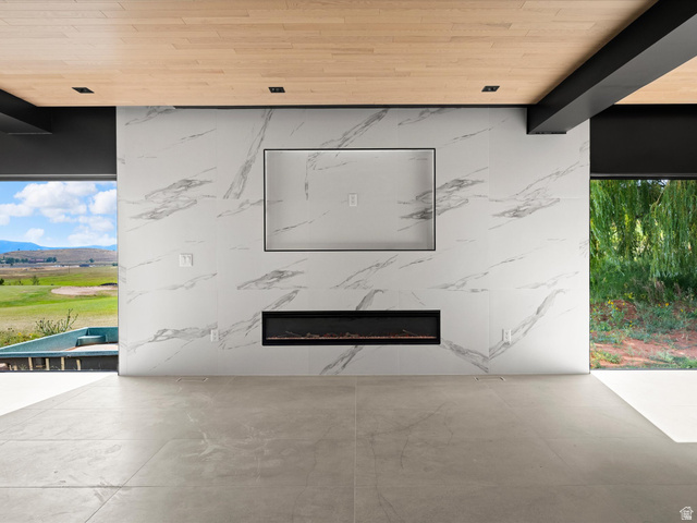 2610 Foxridge Road Garden City, UT 84028 - Photo 22 of 71 Feature wall with large format stone-look tile, integrated linear electric fireplace, and recessed television niche