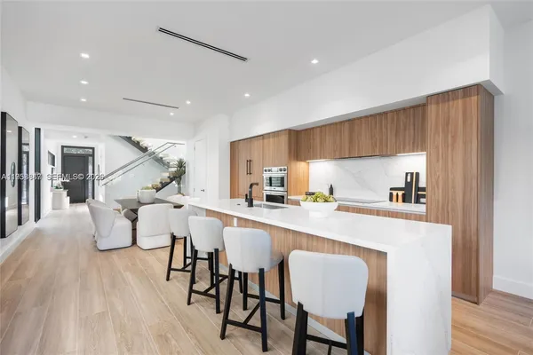 a kitchen with a dining table chairs refrigerator and cabinets