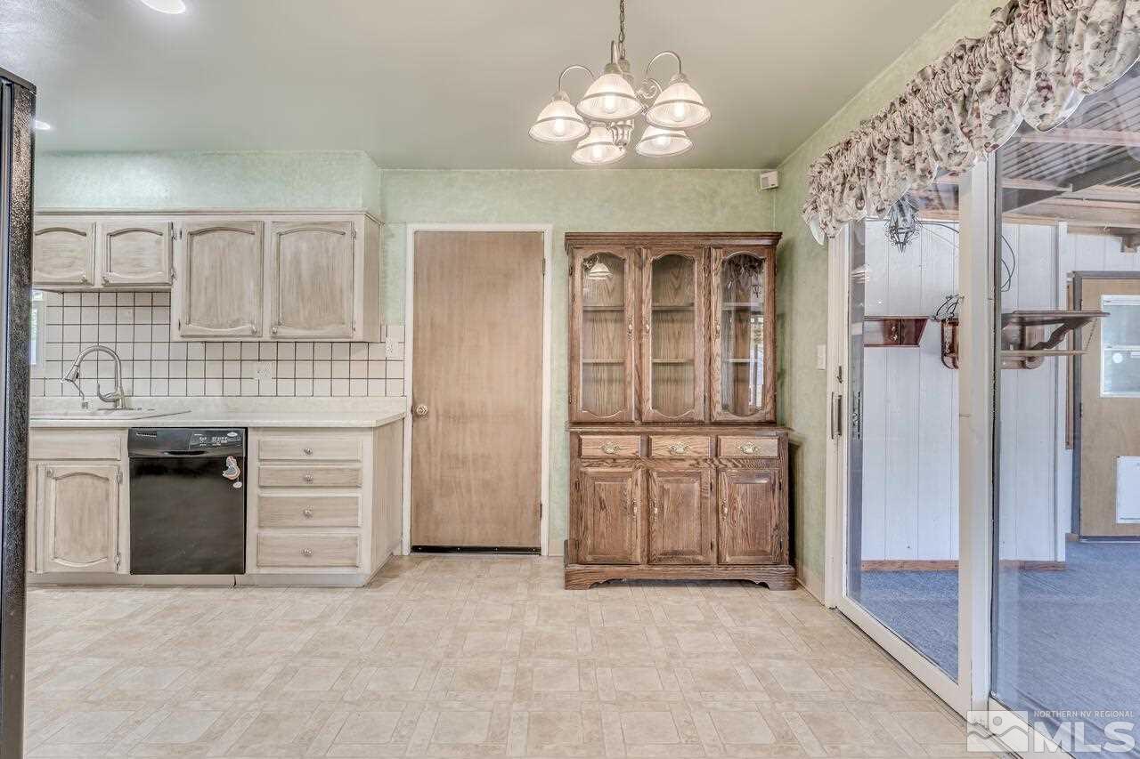 1935 Brisbane Avenue Reno, NV 89503 - Photo 14 of 38 an empty room with chandelier cabinet flat screen tv and kitchen view