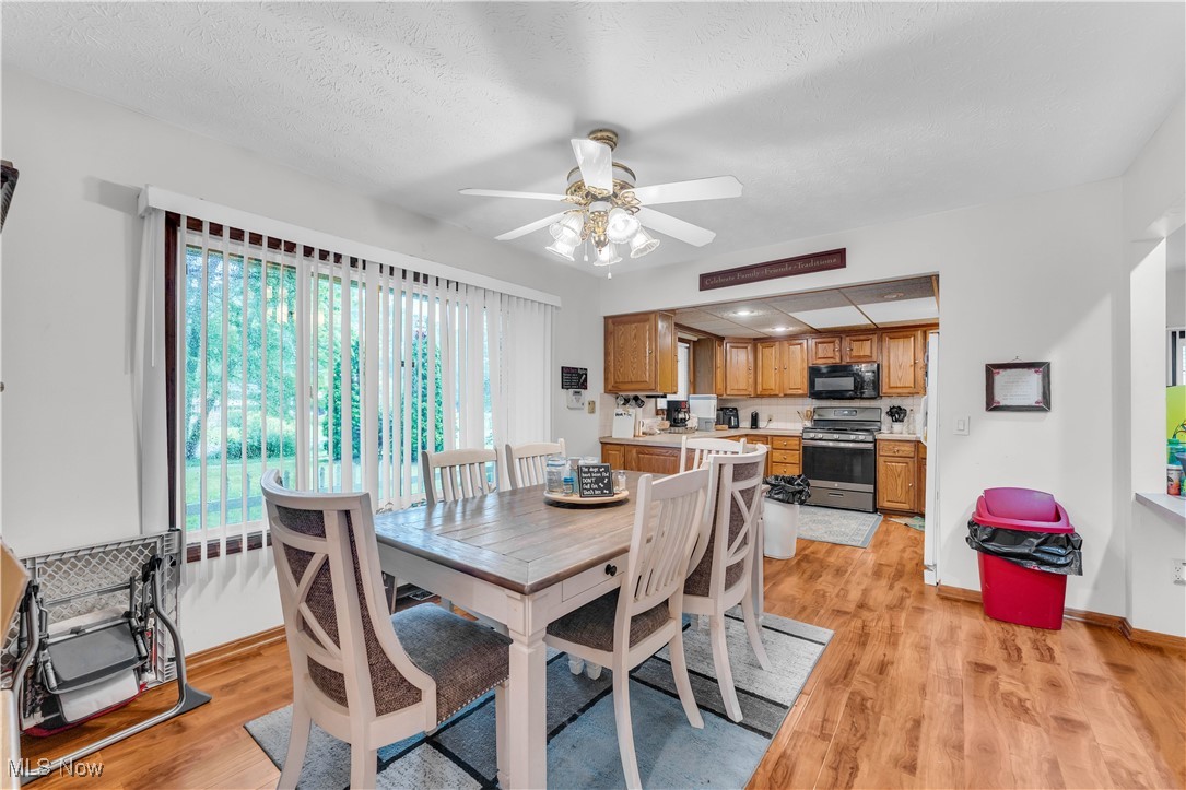 6834 Glendale Road North Ridgeville, OH 44039 - Photo 5 of 37 Dining area featuring ceiling fan, light wood-style flooring, and a textured ceiling