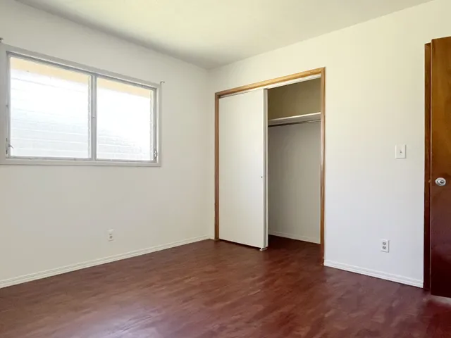 an empty room with wooden floor and a window