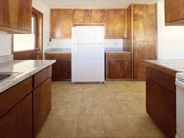 a kitchen with a refrigerator sink stove and cabinets