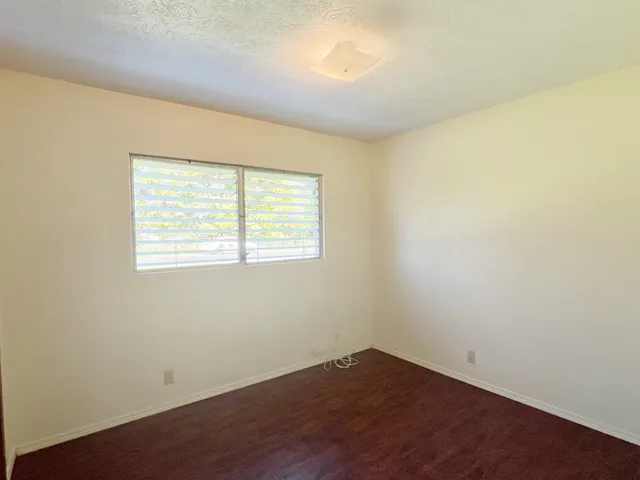 an empty room with wooden floor and a window