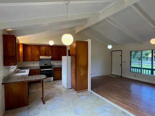 a kitchen with stainless steel appliances kitchen island granite countertop a refrigerator and a stove top oven