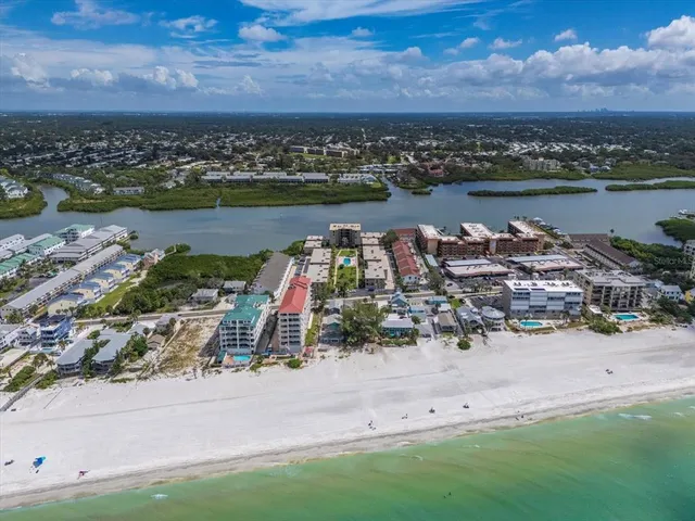 an aerial view of ocean and residential houses with outdoor space