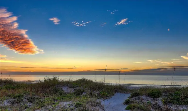 a kitchen with stainless steel appliances a sink a stove a refrigerator cabinets and dining table