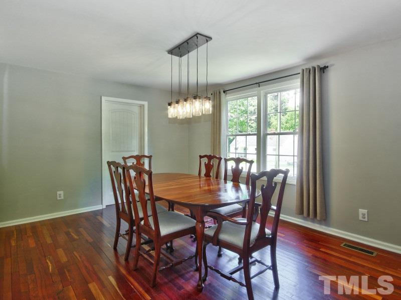 311 Colleton Road Raleigh, NC 27610 - Photo 5 of 22 a dining room with furniture a chandelier and wooden floor