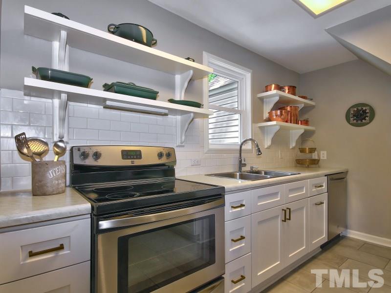 311 Colleton Road Raleigh, NC 27610 - Photo 7 of 22 a kitchen with stainless steel appliances a stove and cabinets