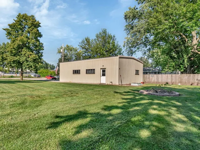 a front view of a house with a yard and trees
