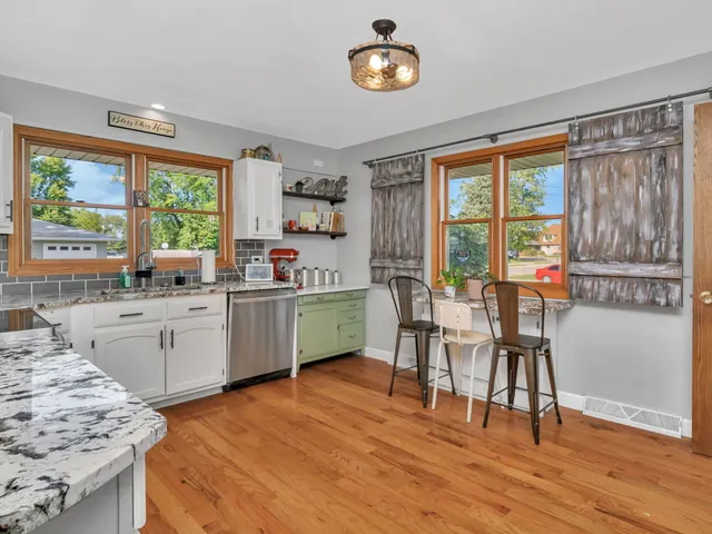 a kitchen with a sink stove and wooden floor