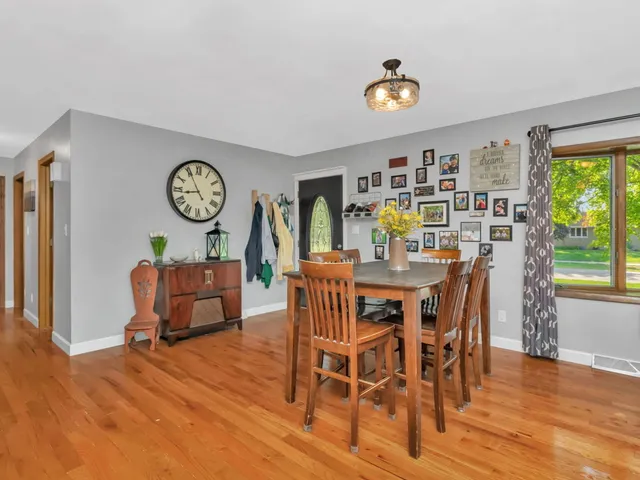a dining room with furniture window and wooden floor