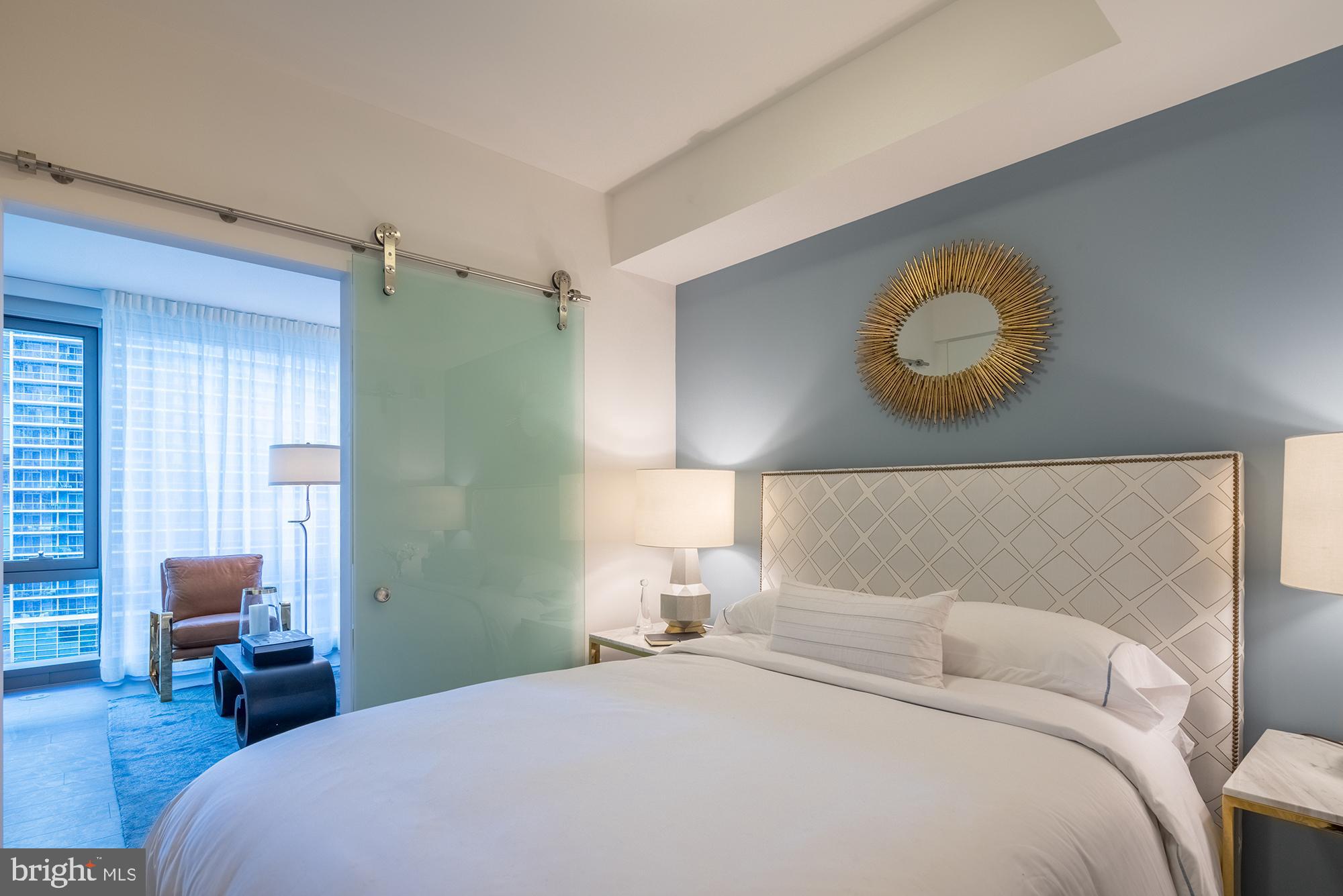 1800 North Lynn Street, Unit 2316 Arlington, VA 22209 - Photo 2 of 11 a bedroom with a bed and a chair