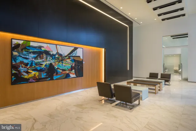 a workspace with furniture wall paintings and a large window