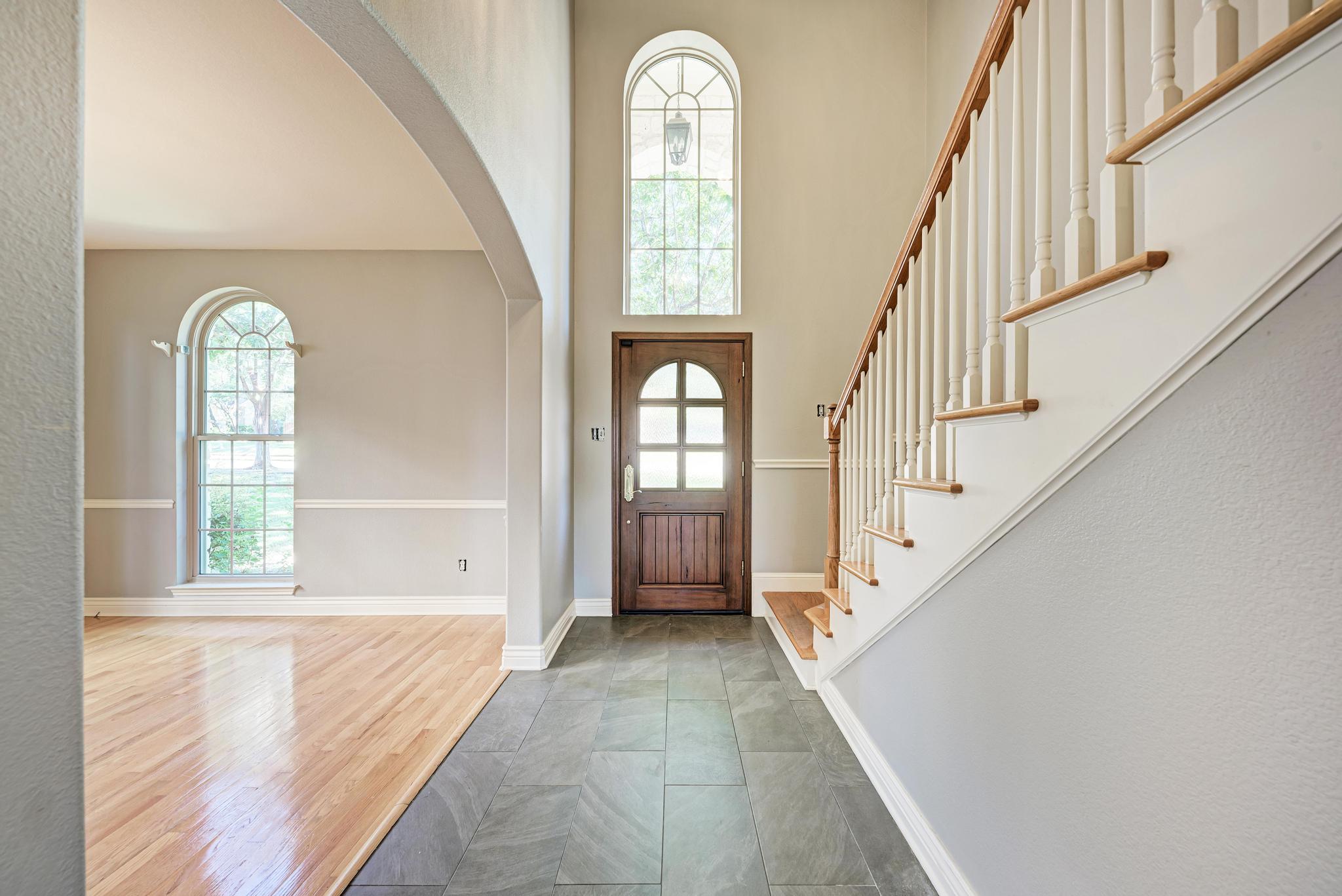 906 Antelope Ridge Cedar Park, TX 78613 - Photo 4 of 40 An arched entry way leads to a grand foyer boasting soaring ceilings and stone tile flooring.