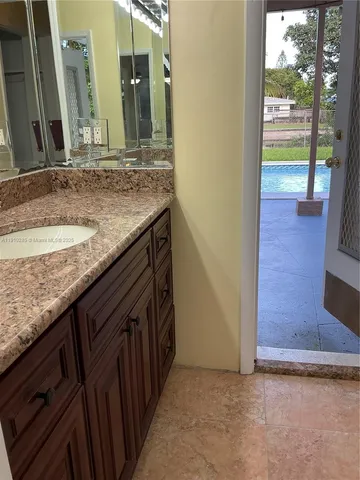 a bathroom with a granite countertop sink and a mirror