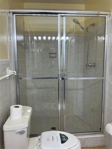 a bathroom with a shower a toilet and a sink