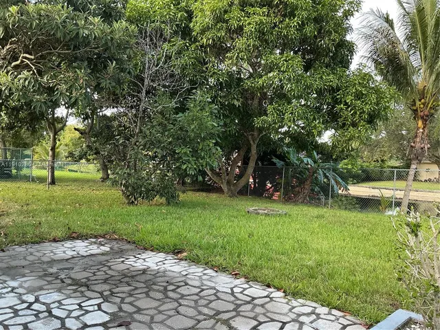 a view of a backyard with large trees