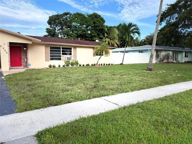 a view of a house with a yard and potted plants